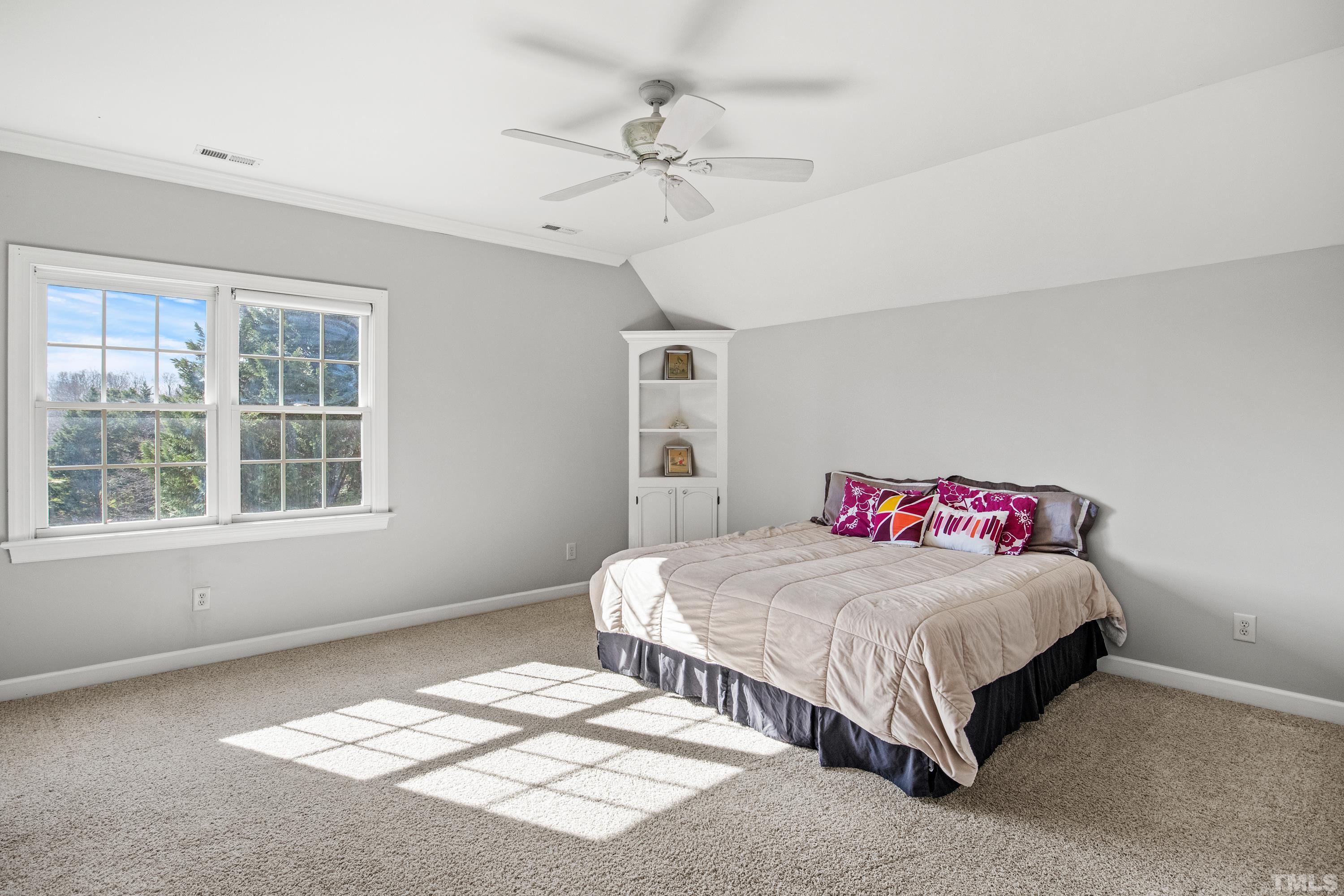 6437 Wakefalls Drive Wake Forest, NC 27587 - Photo 39 of 76 a bedroom with a bed and a chandelier