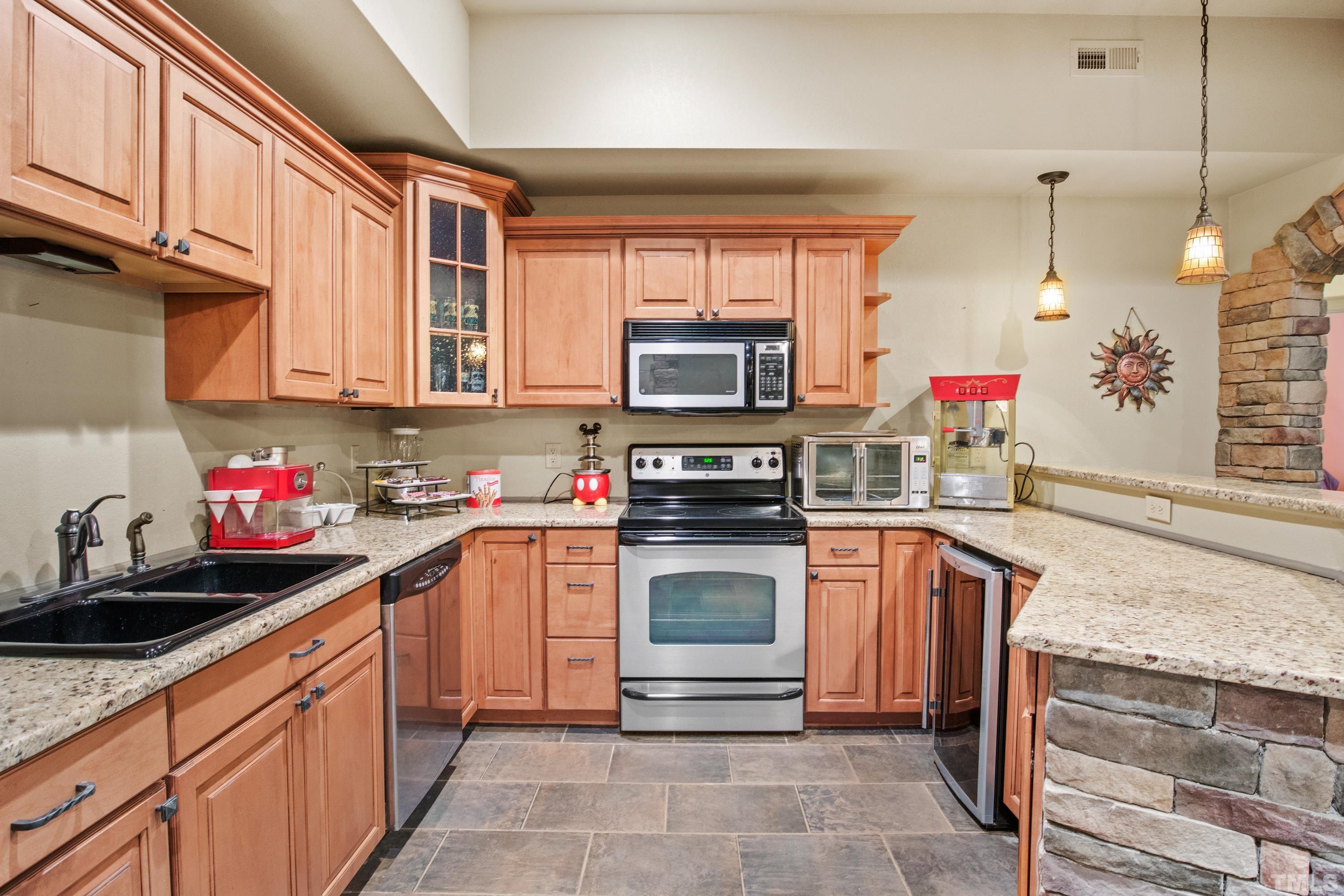 6437 Wakefalls Drive Wake Forest, NC 27587 - Photo 50 of 76 a kitchen with stainless steel appliances granite countertop a sink stove and cabinets