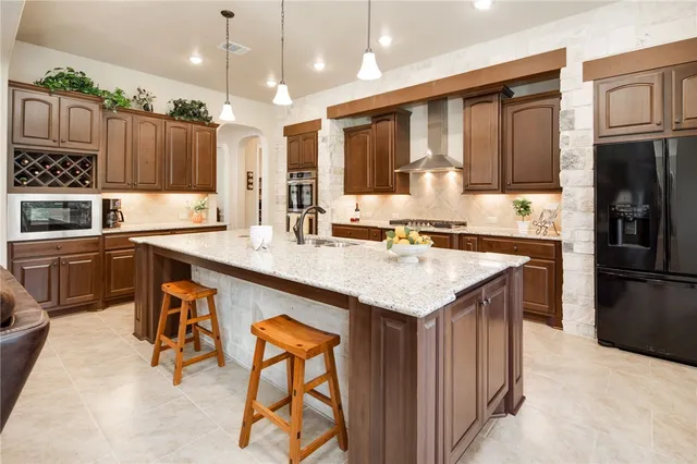 a kitchen with stainless steel appliances granite countertop a sink stove and refrigerator
