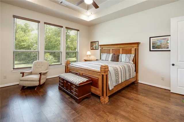 a bathroom with a granite countertop double vanity sink a mirror and a bathtub