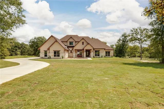 a view of a white house with a large pool and yard