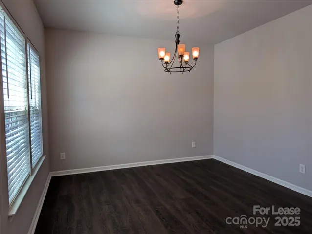 a view of a chandelier in a room with wooden floor and a window