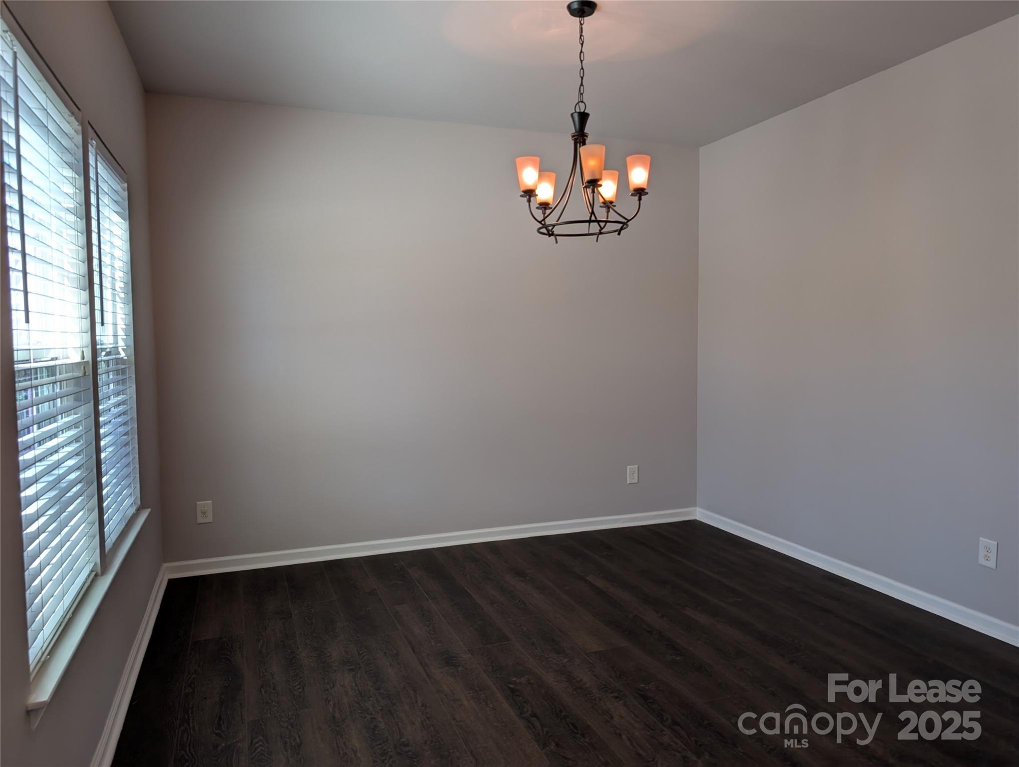 4432 Roundwood Court Indian Trail, NC 28079 - Photo 3 of 25 a view of a chandelier in a room with wooden floor and a window
