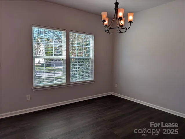 a view of wooden floor and a chandelier fan in a room