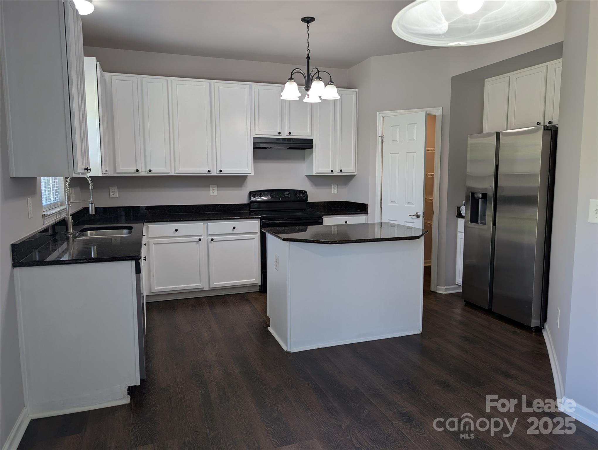 4432 Roundwood Court Indian Trail, NC 28079 - Photo 5 of 25 a kitchen with stainless steel appliances granite countertop a refrigerator a sink dishwasher a stove and white cabinets with wooden floor