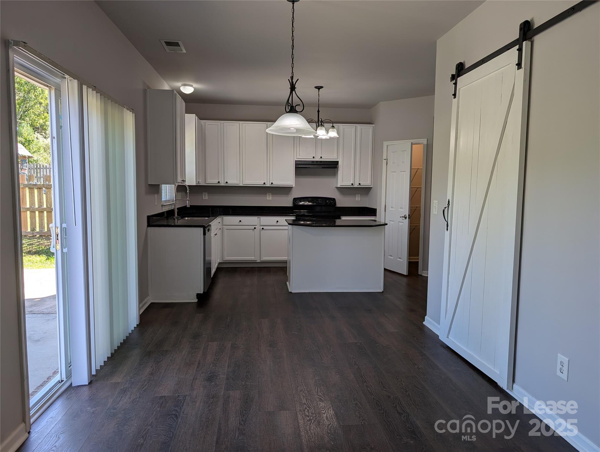 4432 Roundwood Court Indian Trail, NC 28079 - Photo 6 of 25 a kitchen with stainless steel appliances granite countertop a refrigerator a sink dishwasher a stove and white countertops with wooden floor