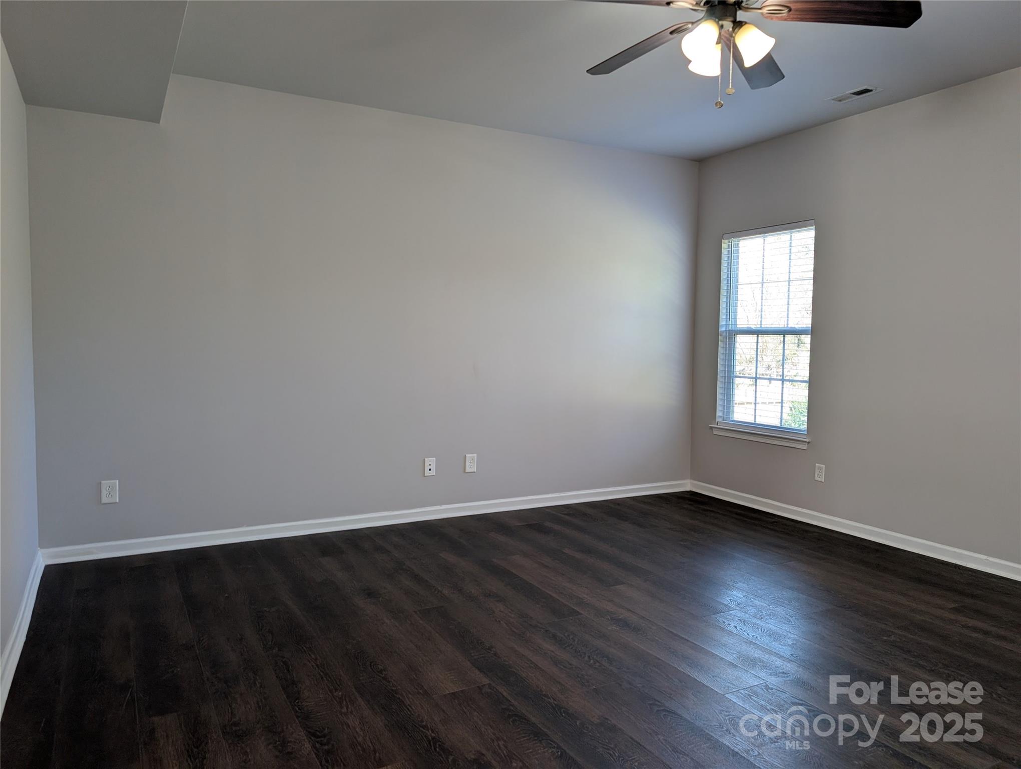 4432 Roundwood Court Indian Trail, NC 28079 - Photo 7 of 25 an empty room with wooden floor and windows
