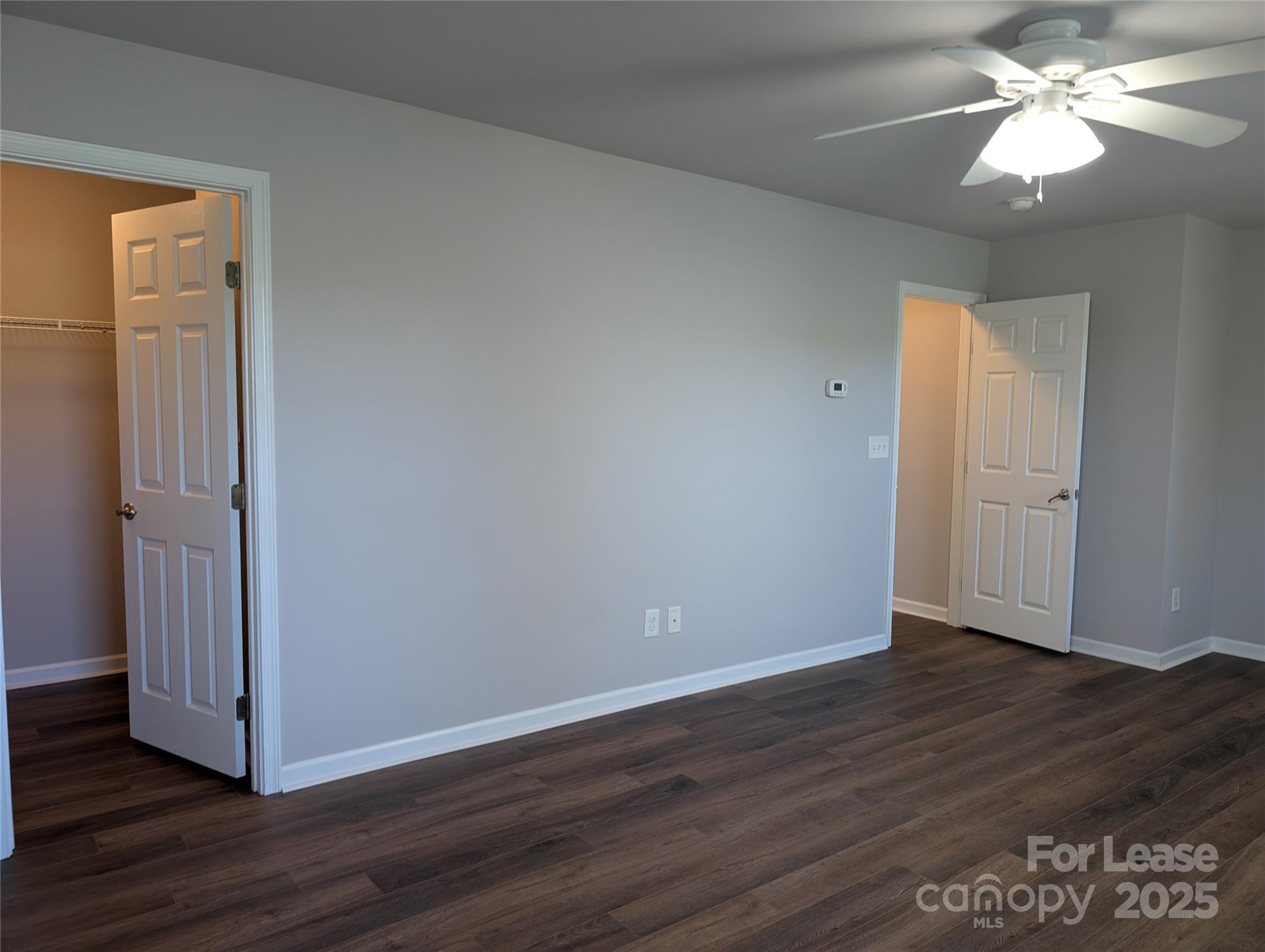 4432 Roundwood Court Indian Trail, NC 28079 - Photo 10 of 25 an empty room with wooden floor and a ceiling fan