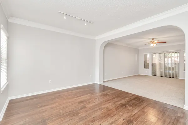 an empty room with wooden floor and windows