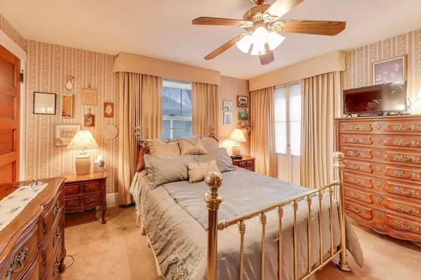 a bedroom with a large bed a flat tv screen and dresser