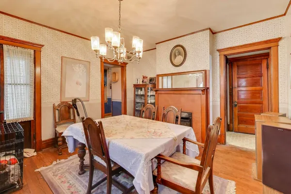 a dining room with furniture a chandelier and wooden floor