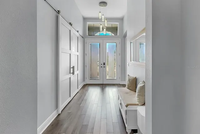 a view of a hallway with wooden floor and entryway