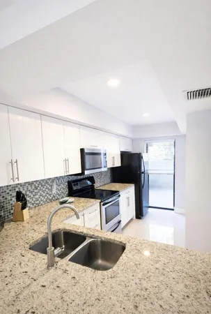 a kitchen with stainless steel appliances kitchen island a stove a sink and a refrigerator