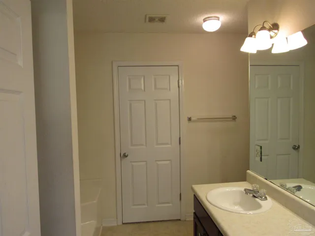 a bathroom with a sink a light fixture and a mirror