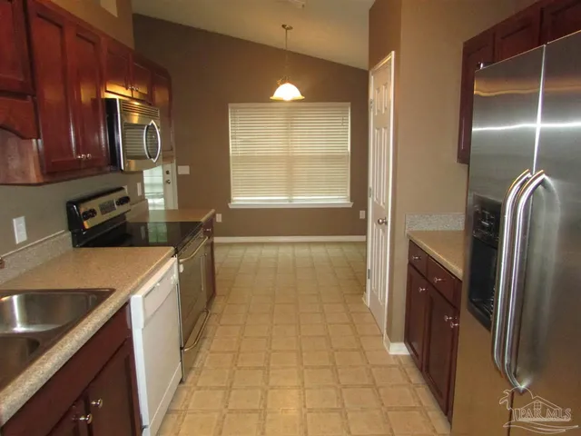a kitchen with granite countertop a refrigerator and a sink