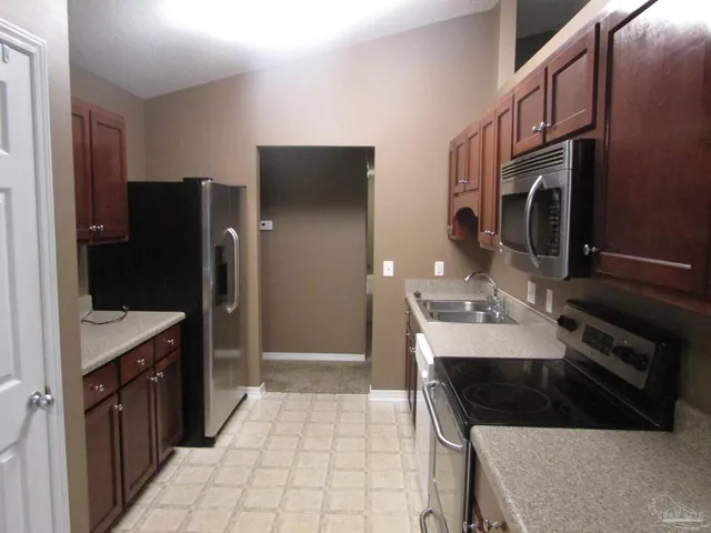 a kitchen with a sink a refrigerator and cabinets