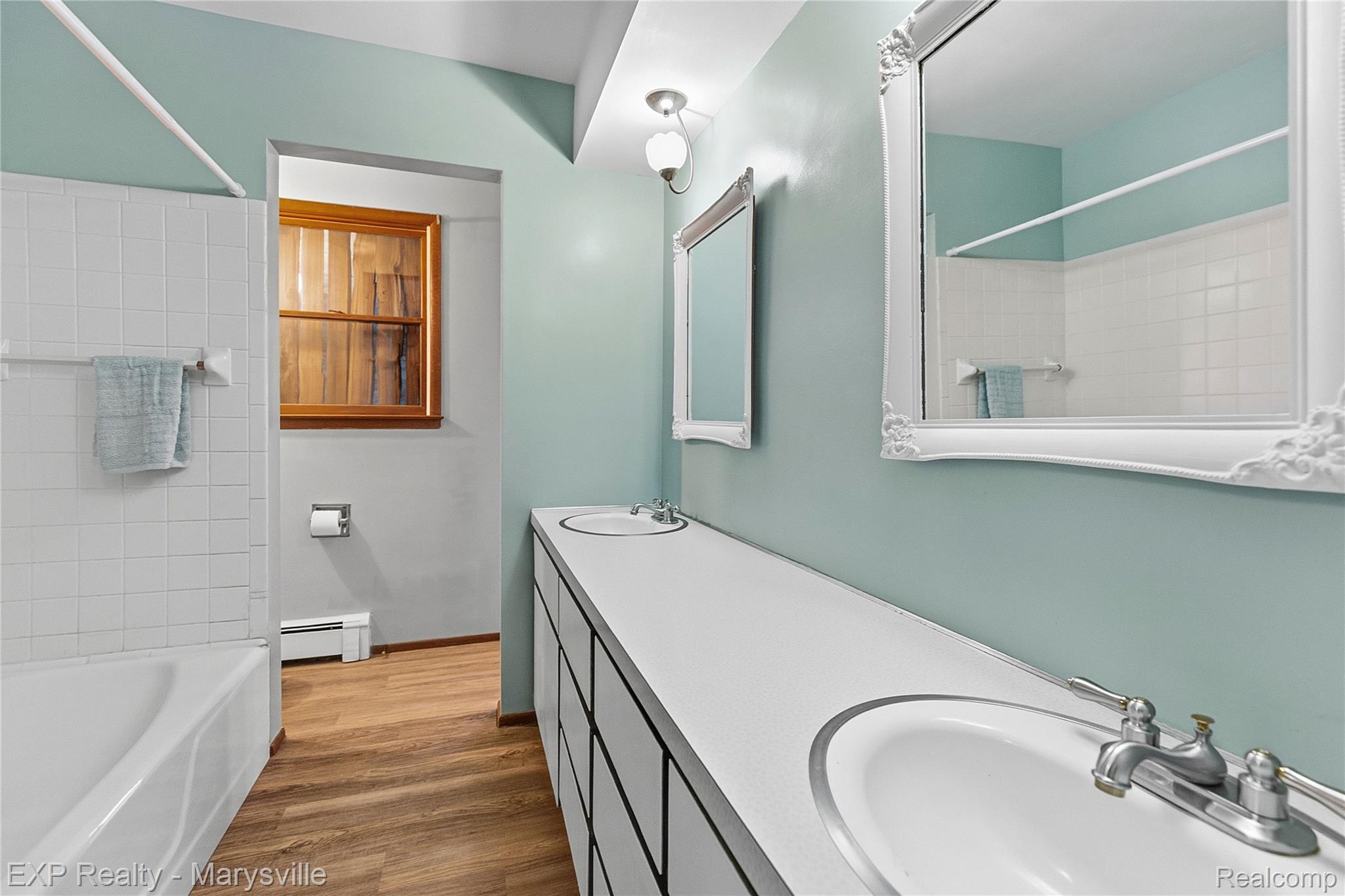 3345 Beach Road Port Huron, MI 48060 - Photo 13 of 89 Full bath with shower / bathtub combination, double vanity, dark wood finished floors, and a baseboard radiator