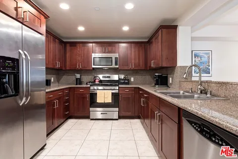 a kitchen with stainless steel appliances granite countertop a refrigerator stove a sink and dishwasher
