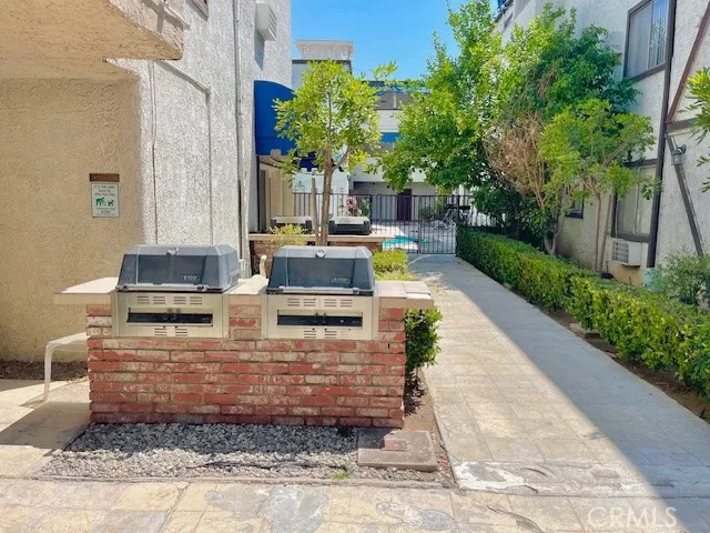 a view of house with a large window and potted plants