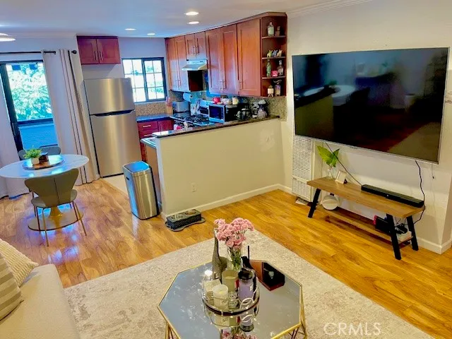 a room with stainless steel appliances kitchen island granite countertop furniture and a view of kitchen