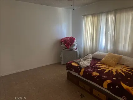 a bed sitting in a bedroom next to a window