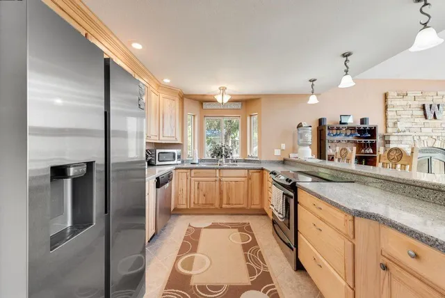 a kitchen with stainless steel appliances granite countertop a stove and a sink