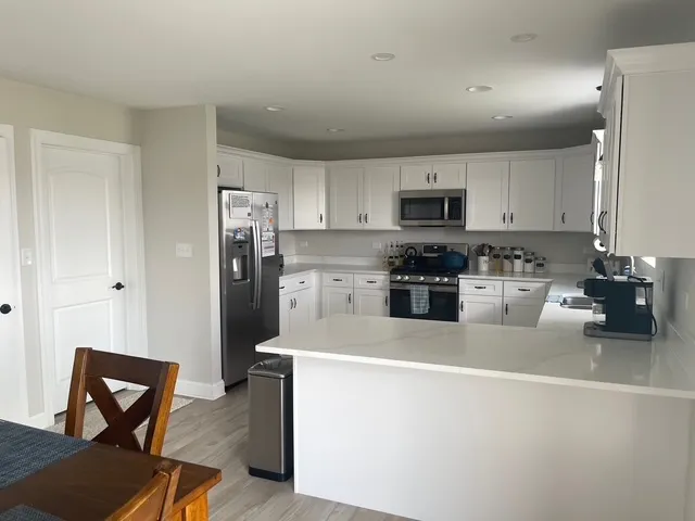 a kitchen with stainless steel appliances granite countertop a refrigerator stove microwave and sink