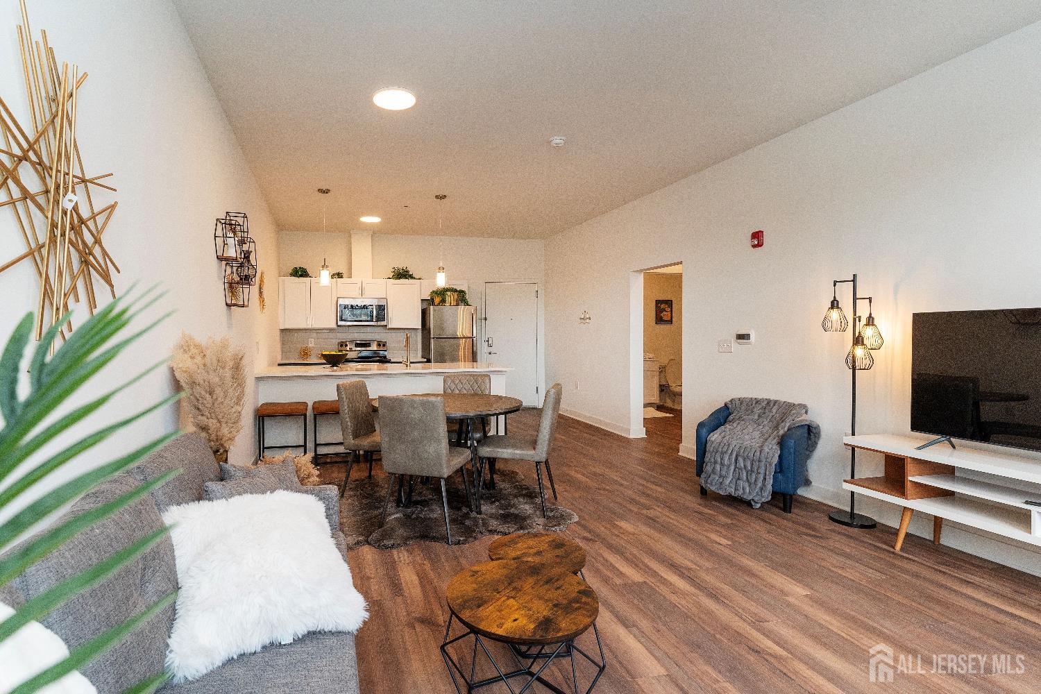 18 West Main Street, Unit 407 Bound Brook, NJ 08805 - Photo 2 of 28 a living room with furniture and a flat screen tv