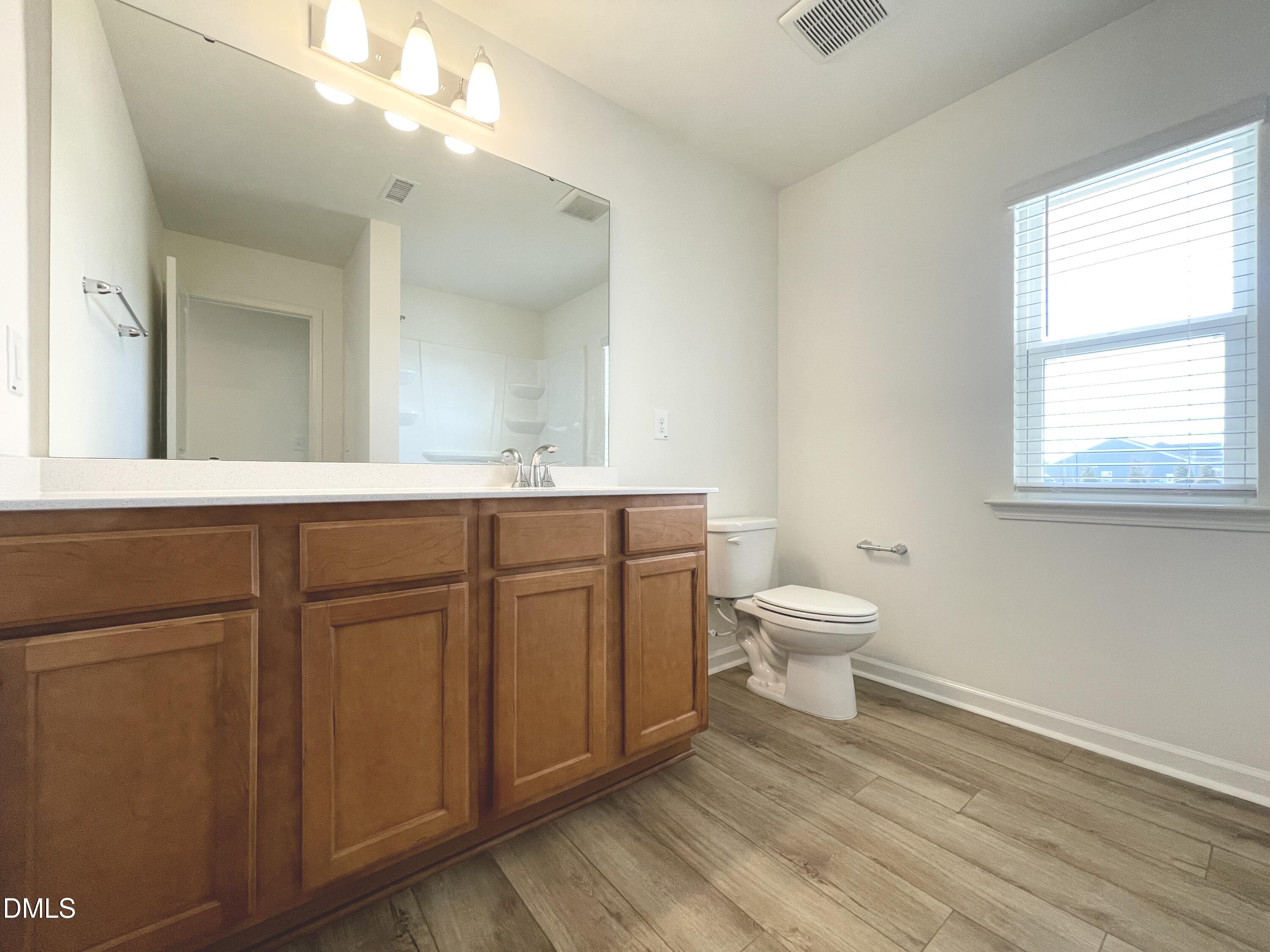 6117 Oak Psge Drive Raleigh, NC 27603 - Photo 19 of 25 a bathroom with a toilet a sink and a mirror