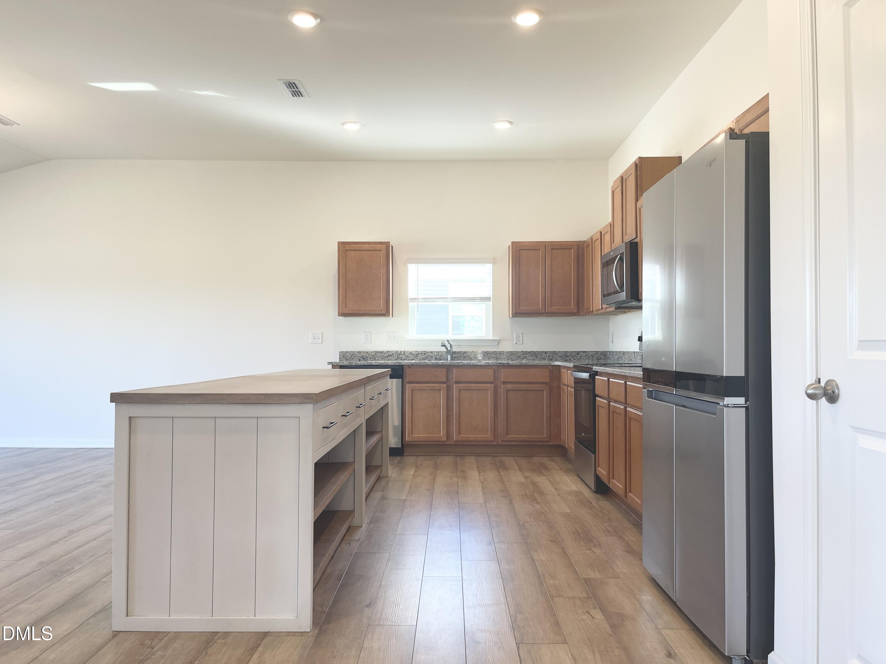 6117 Oak Psge Drive Raleigh, NC 27603 - Photo 8 of 25 a kitchen with stainless steel appliances white cabinets and wooden floor