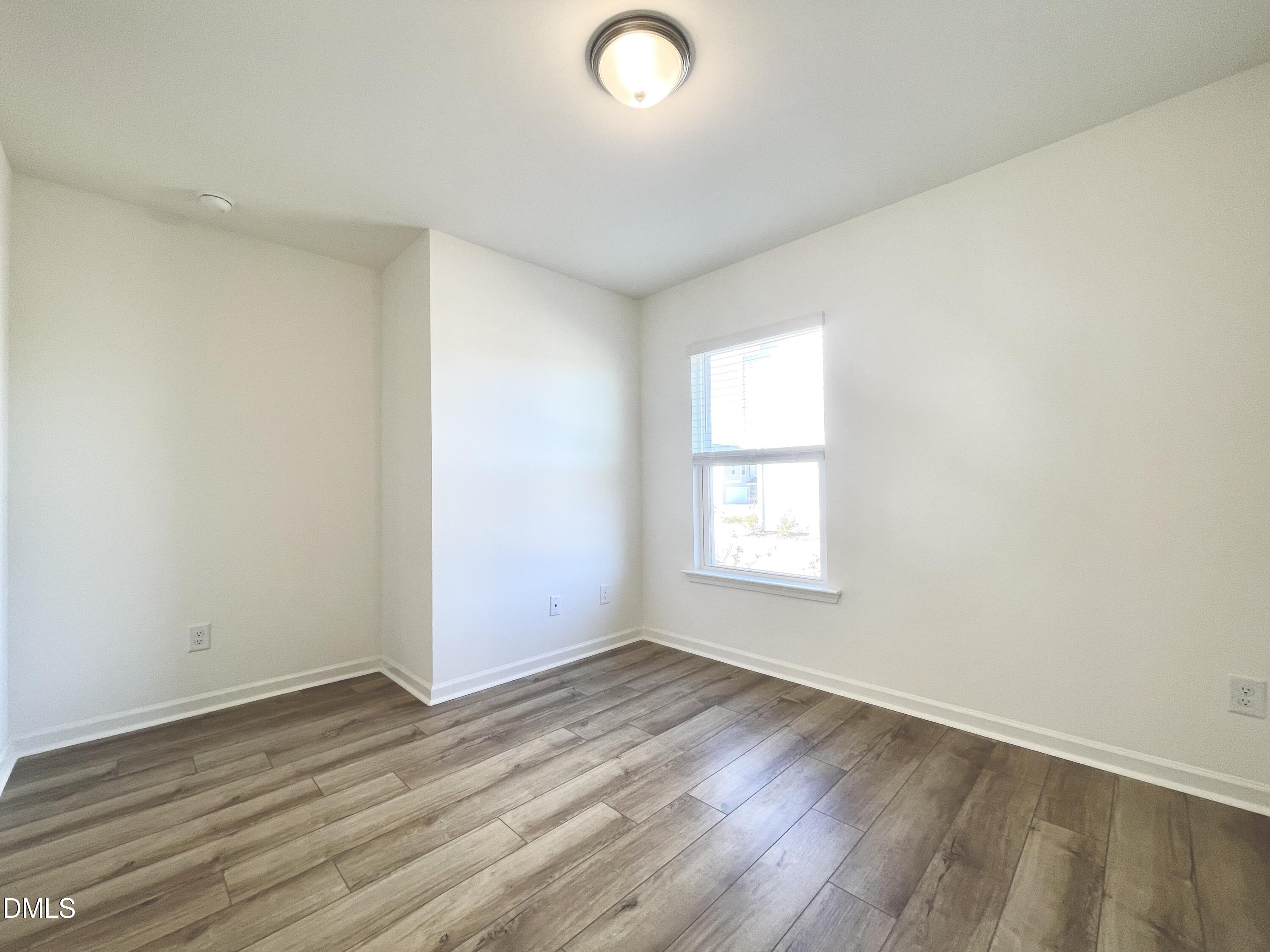 6117 Oak Psge Drive Raleigh, NC 27603 - Photo 10 of 25 an empty room with wooden floor and windows