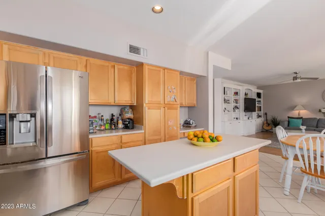 a kitchen with stainless steel appliances granite countertop a refrigerator a stove a sink dishwasher and a dining table with wooden floor