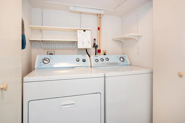 a view of a hallway with wooden floor and a refrigerator