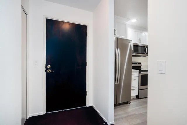 a kitchen with cabinets stainless steel appliances and wooden floor