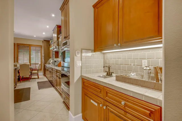 a kitchen with kitchen island granite countertop wooden cabinets and a refrigerator