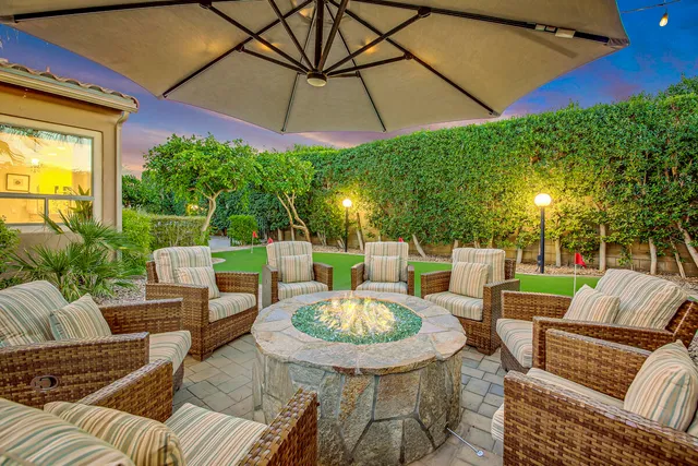 a view of a patio with table and chairs potted plants and palm trees