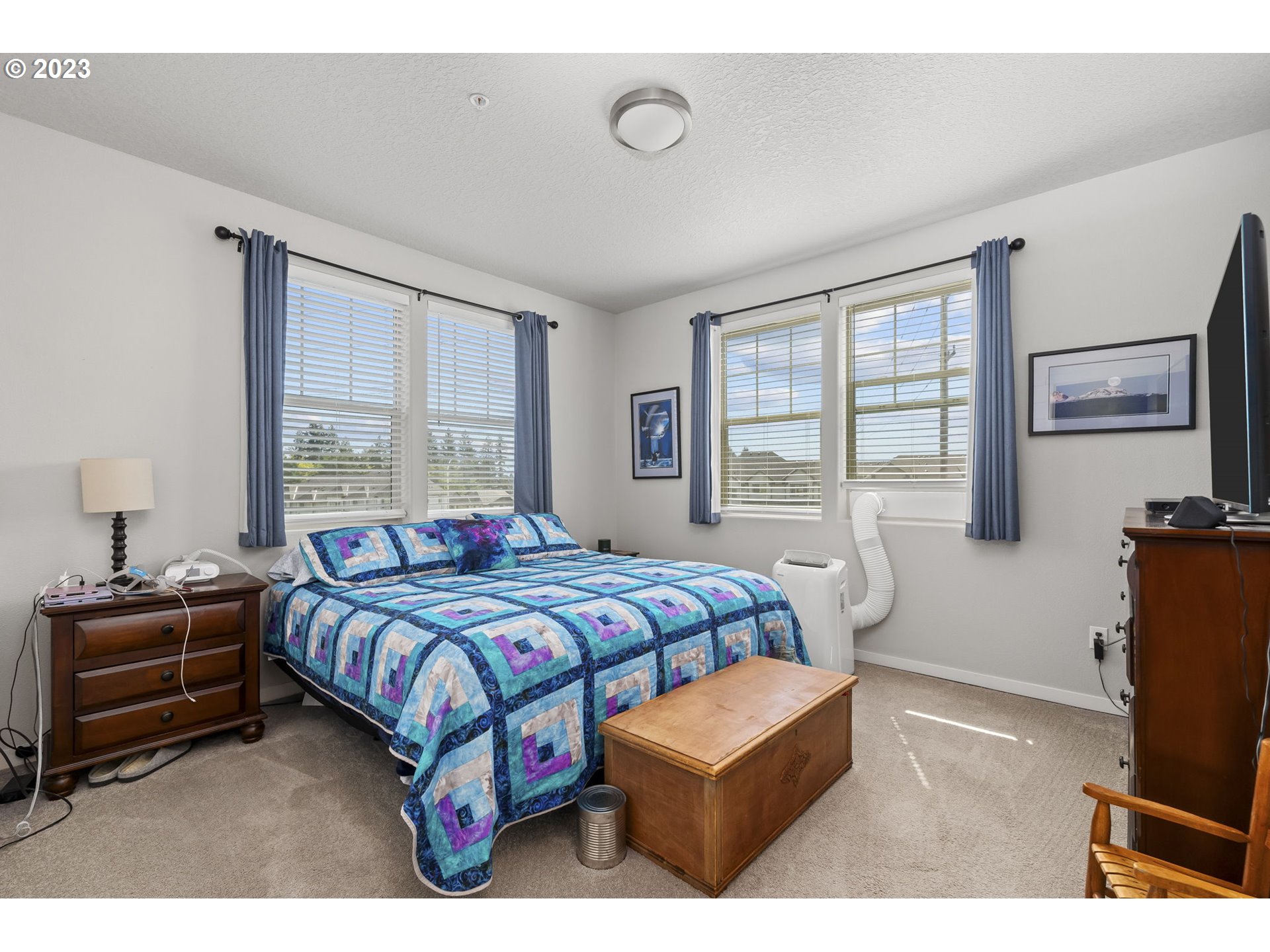 17051 Southwest Appledale Road, Unit 204 Beaverton, OR 97007 - Photo 15 of 23 a bedroom with a bed a couch and large windows