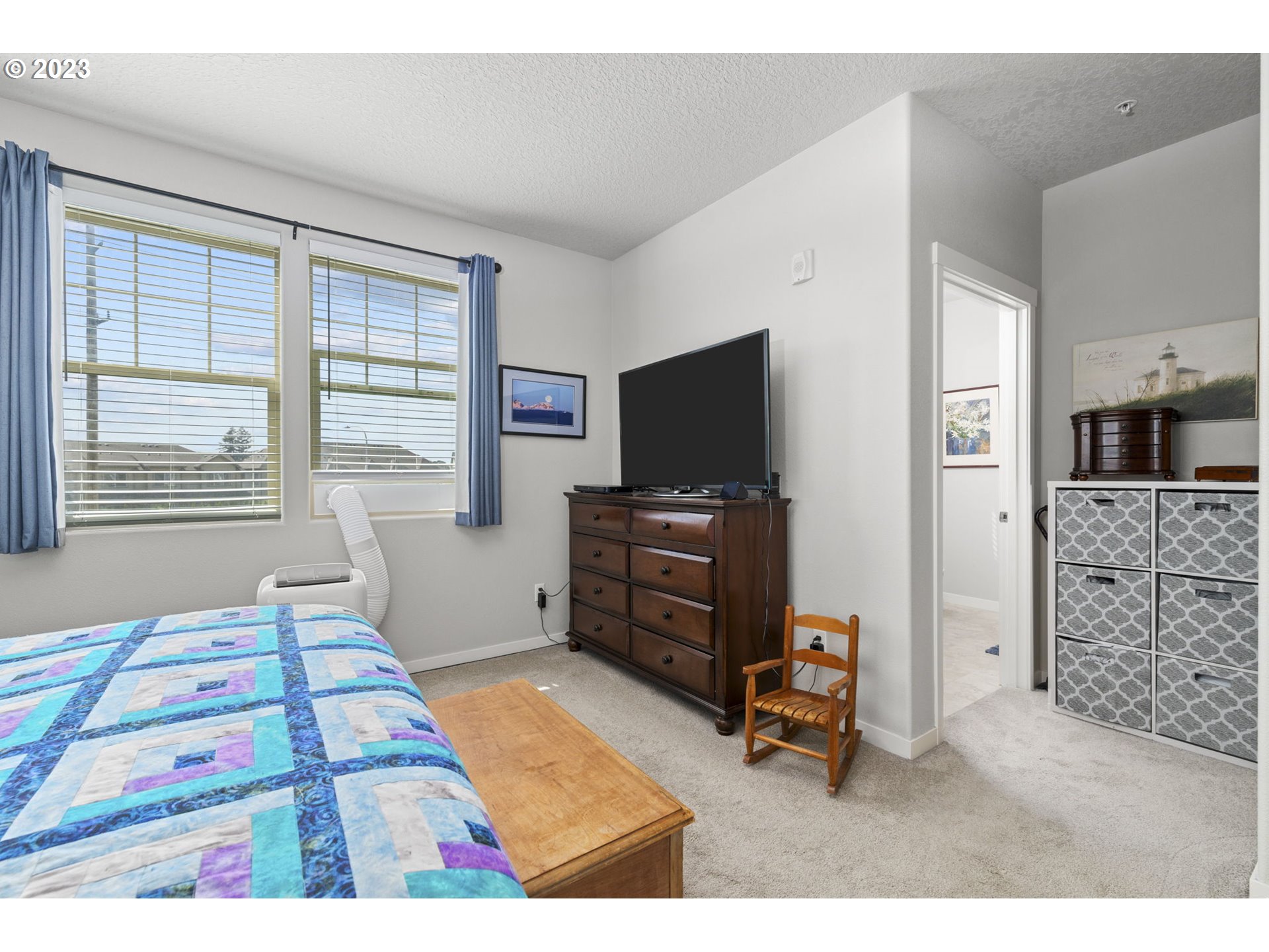 17051 Southwest Appledale Road, Unit 204 Beaverton, OR 97007 - Photo 16 of 23 a bedroom with furniture and a flat screen tv