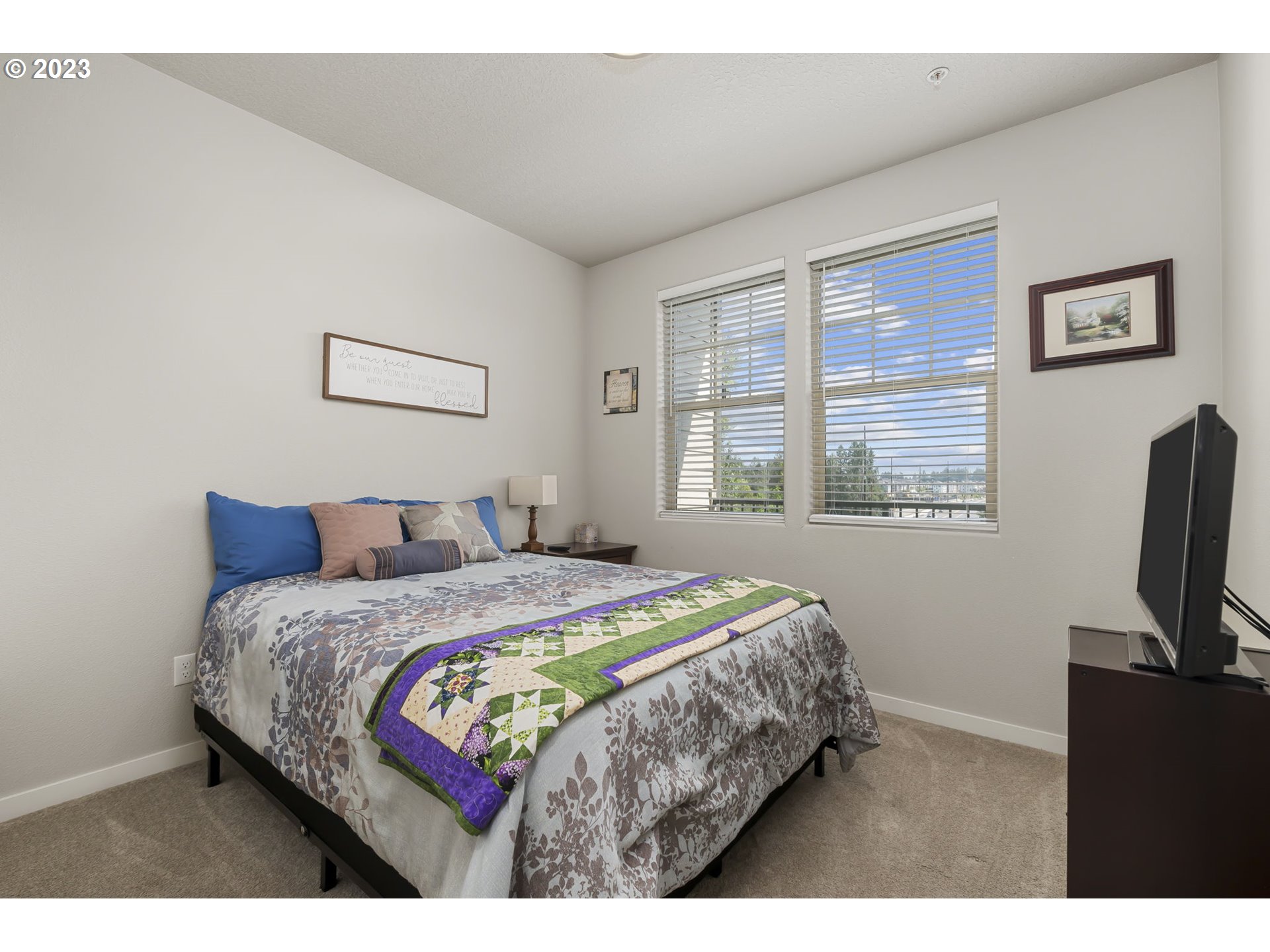 17051 Southwest Appledale Road, Unit 204 Beaverton, OR 97007 - Photo 3 of 23 a bedroom with a bed a mirror and a flat tv screen