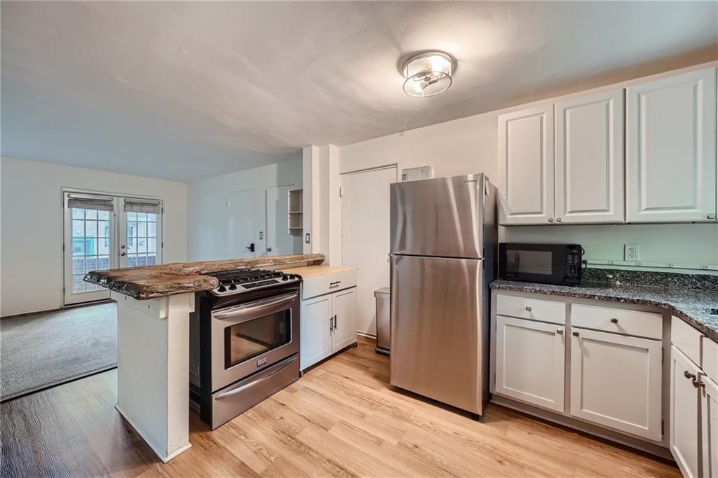 1381 Normandy Drive Northeast, Unit 2 Atlanta, GA 30306 - Photo 6 of 12 a kitchen with a stove refrigerator and microwave