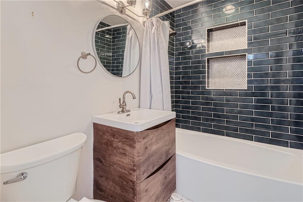 1381 Normandy Drive Northeast, Unit 2 Atlanta, GA 30306 - Photo 8 of 12 a bathroom with a sink a toilet and shower