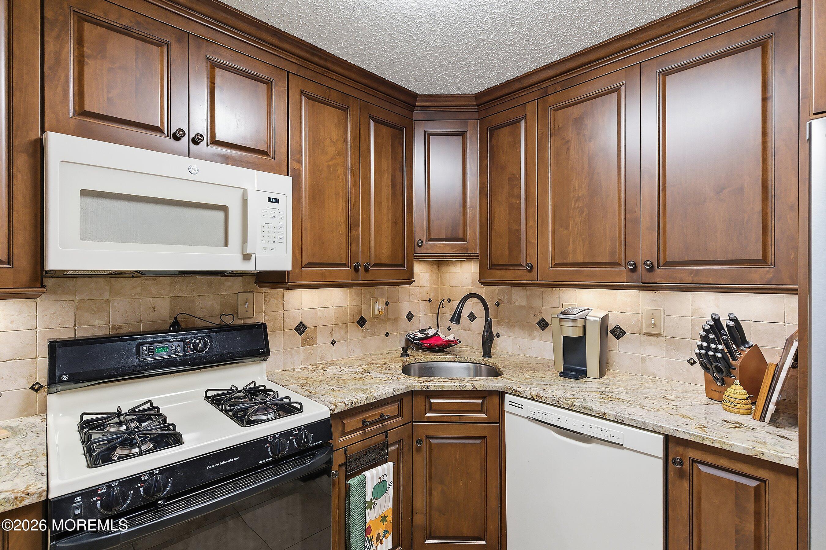 8-2 Seattle Court Freehold, NJ 07728 - Photo 13 of 35 a kitchen with stainless steel appliances granite countertop a sink stove and cabinets