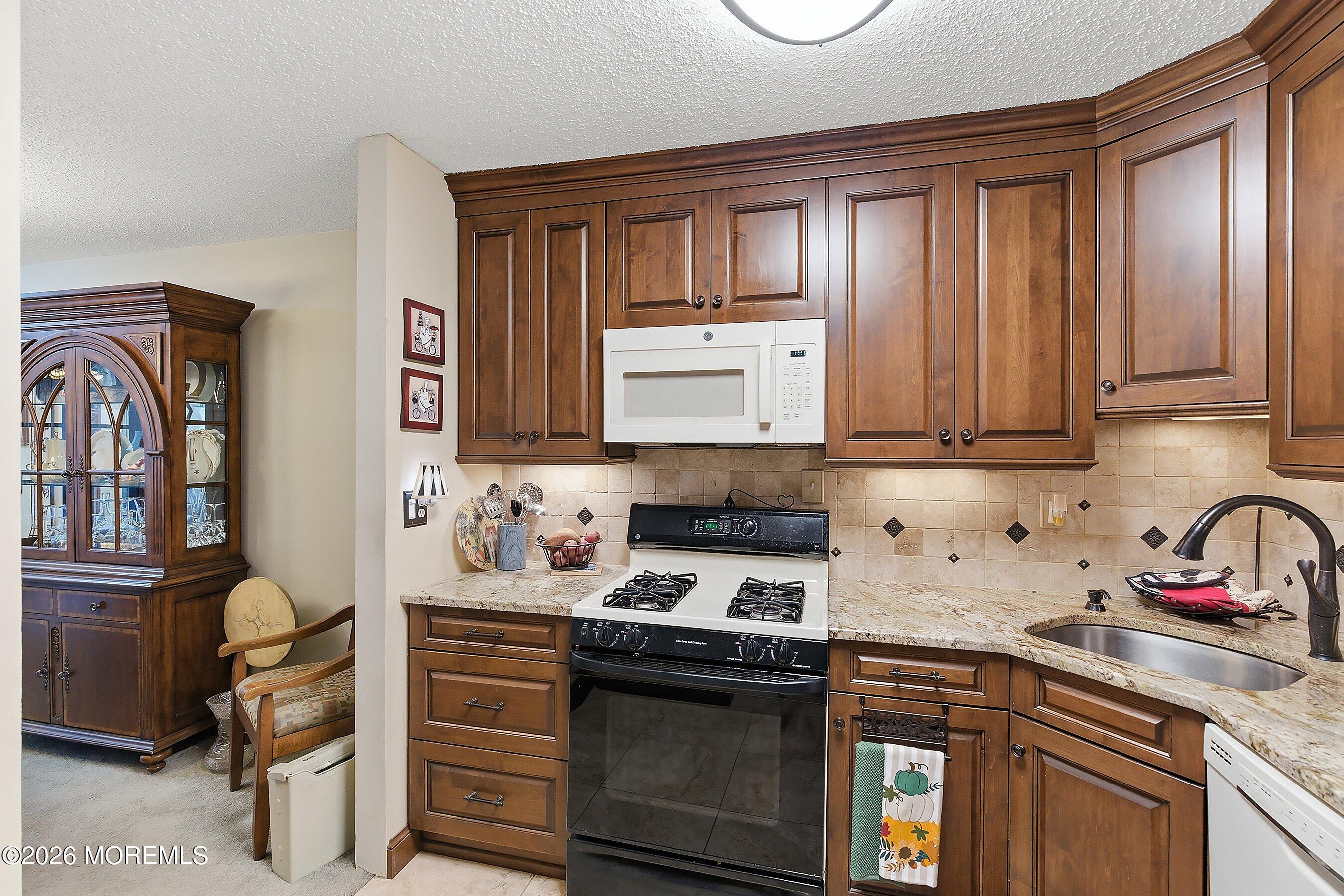 8-2 Seattle Court Freehold, NJ 07728 - Photo 14 of 35 a kitchen with stainless steel appliances granite countertop a sink stove and cabinets