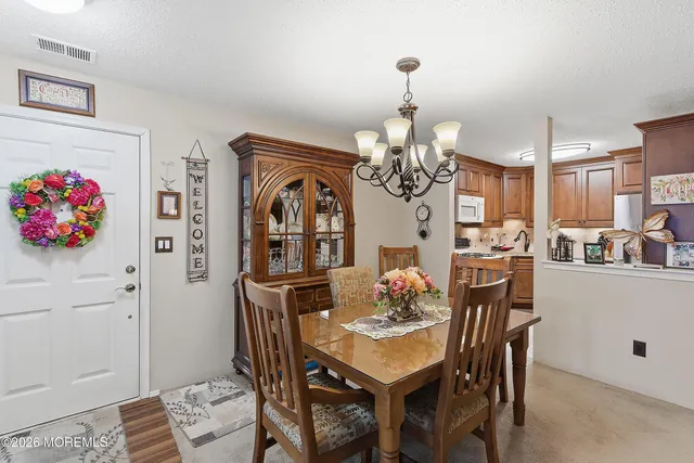 a view of a dining room with furniture and chandelier