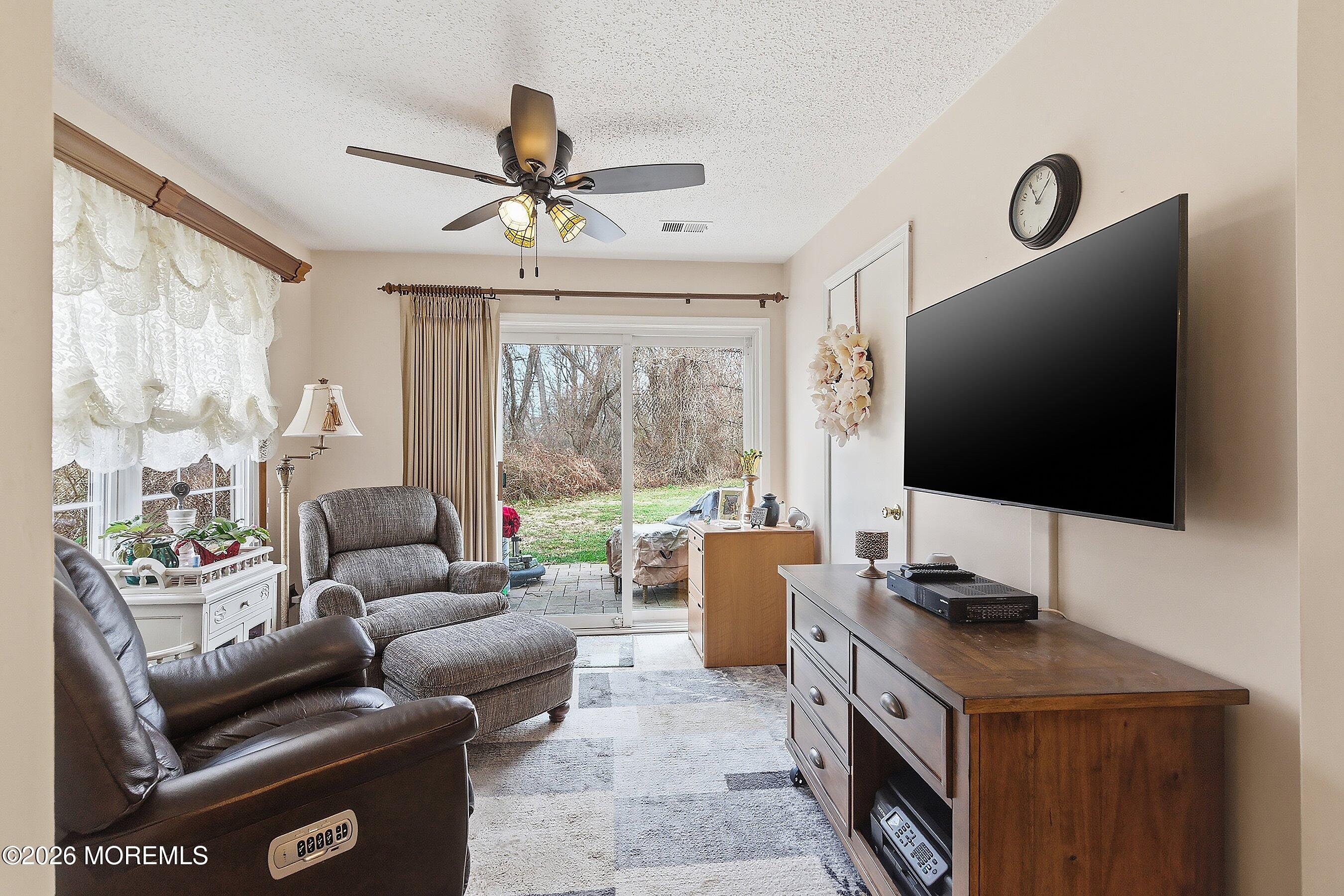 8-2 Seattle Court Freehold, NJ 07728 - Photo 7 of 35 a living room with furniture a flat screen tv and a large window