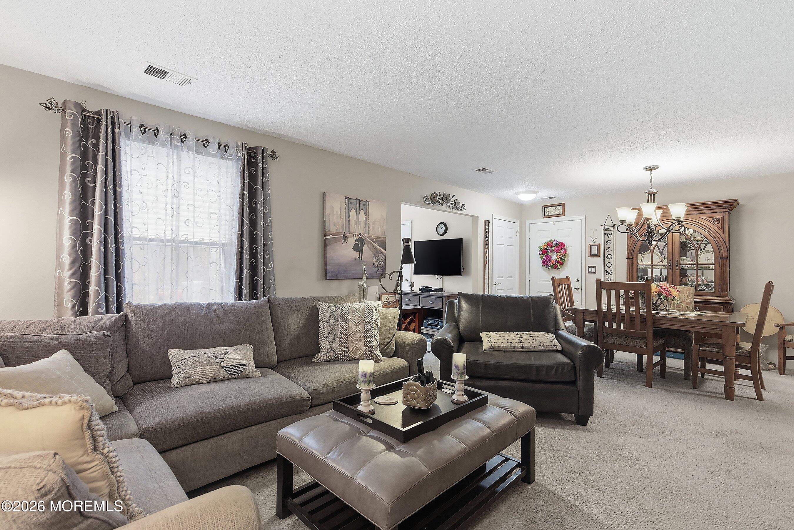 8-2 Seattle Court Freehold, NJ 07728 - Photo 10 of 35 a living room with furniture a large window and a flat screen tv