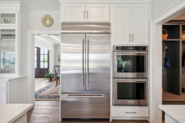 a kitchen with stainless steel appliances granite countertop white cabinets stove and microwave