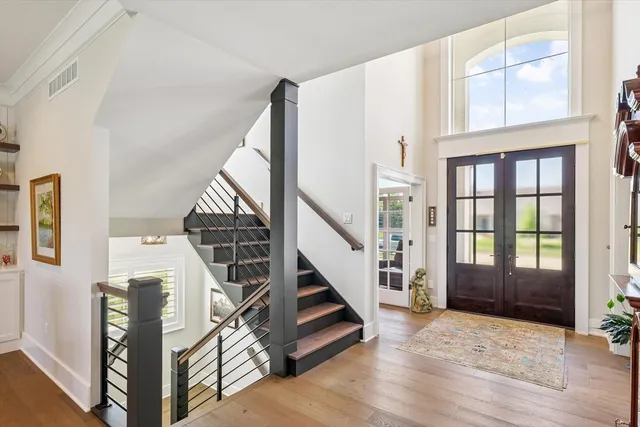 a kitchen with stainless steel appliances granite countertop a stove top oven a sink a dining table and chairs with wooden floor