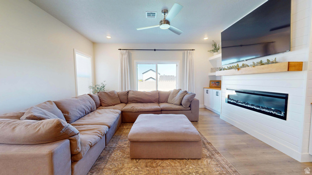 1127 4240 North Enoch, UT 84721 - Photo 12 of 56 Living room featuring ceiling fan, light wood-style flooring, a glass covered fireplace, and recessed lighting
