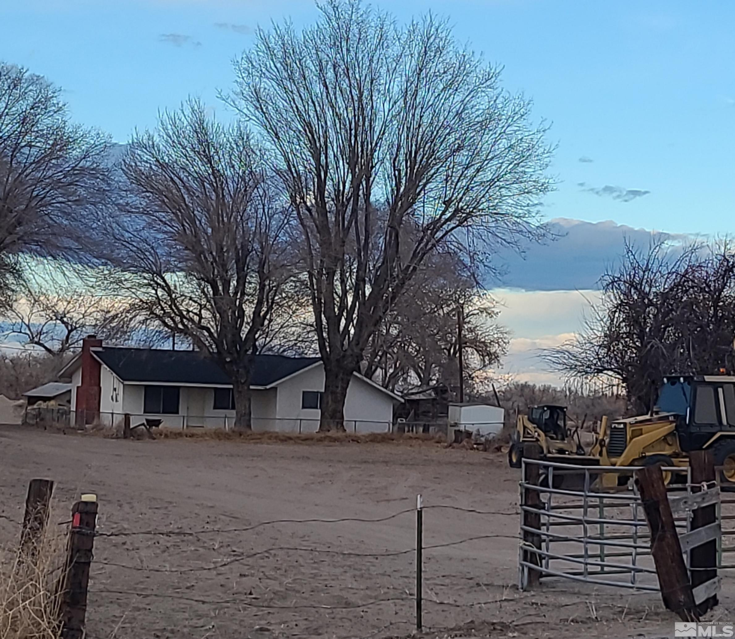1755 Coleman Road Fallon, NV 89406 - Photo 1 of 12 a front view of a house with trees and covered with snow in the background